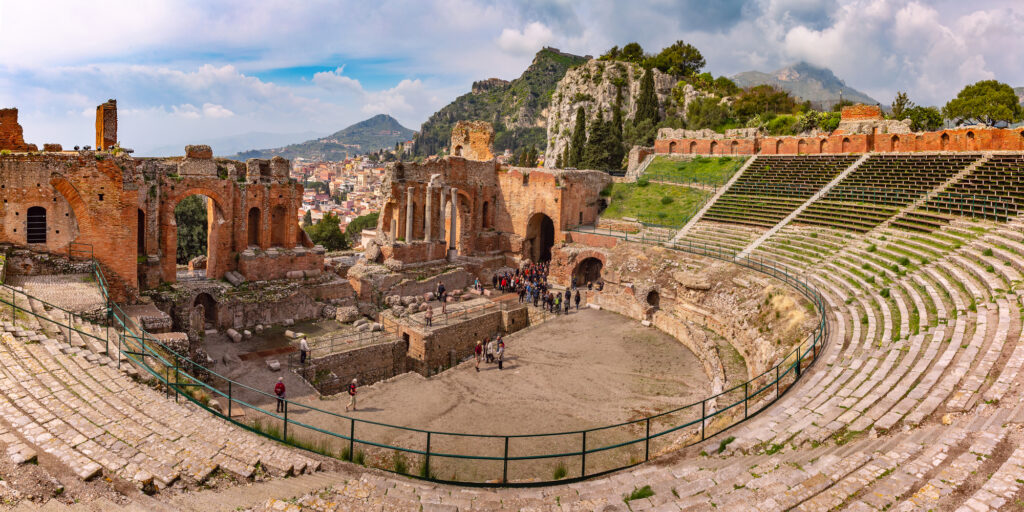 Panoramic view of Ruins of Ancient Greek theatre and Old Town of Taormina in sunny day, Sicily, Italy